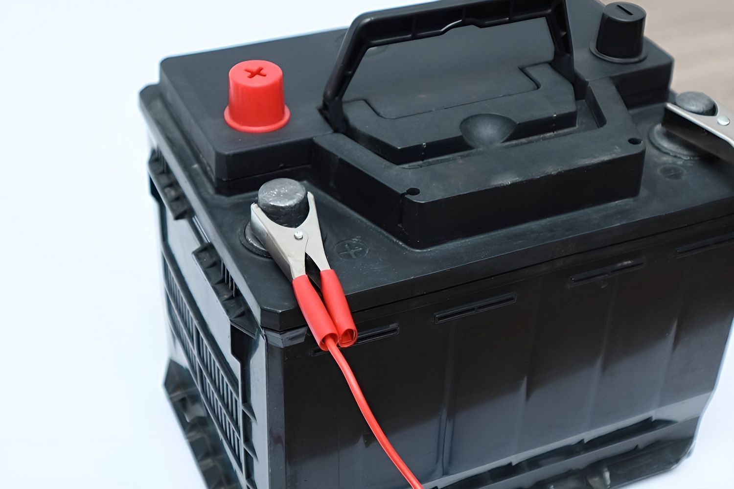 Black Car Battery With Red And Silver Jumper Cable Attached To A Terminal