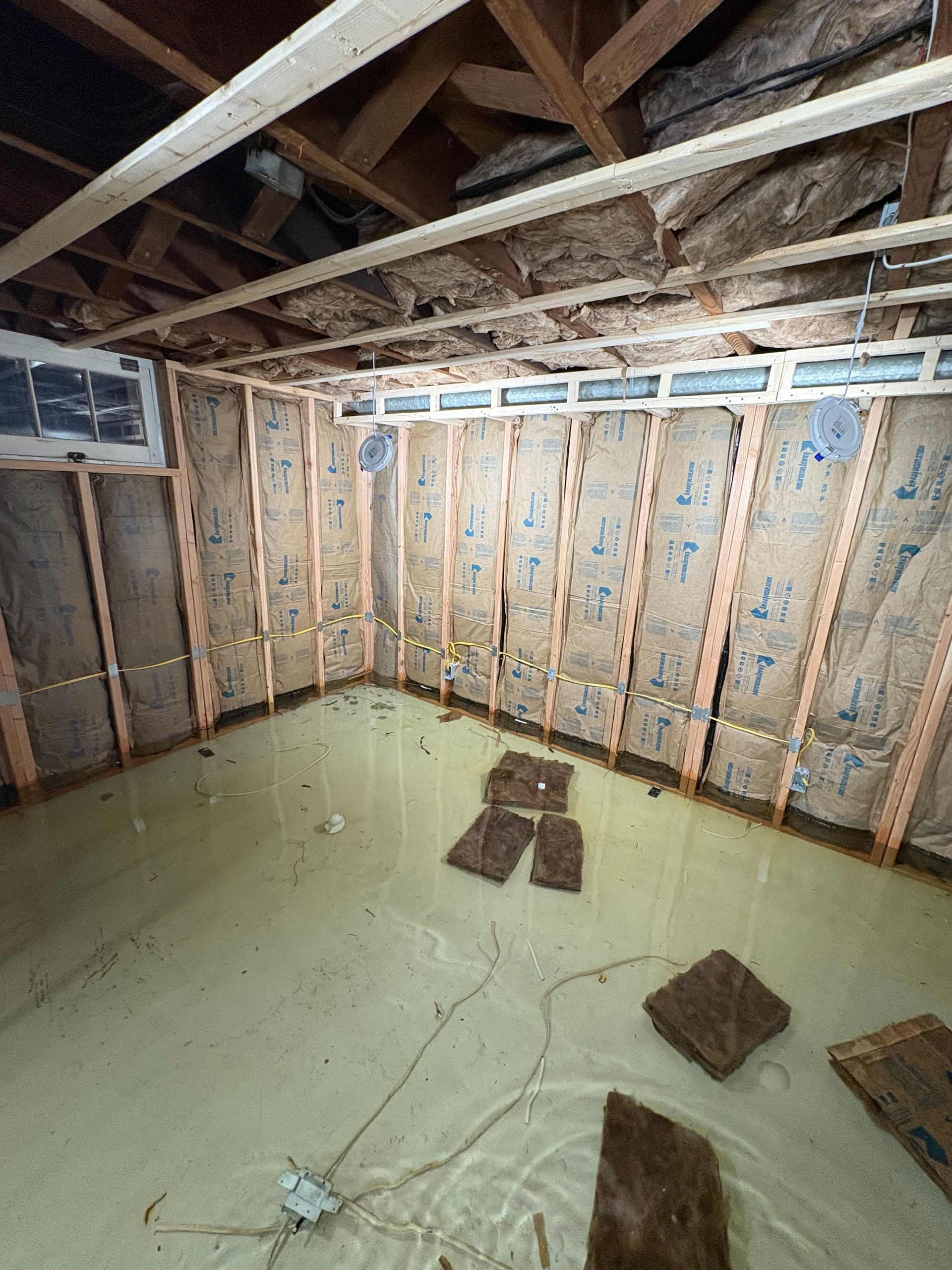 a living room filled with furniture and a flooded floor .