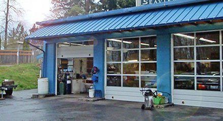 A blue auto shop with a white garage door | Quality Auto & Electric
