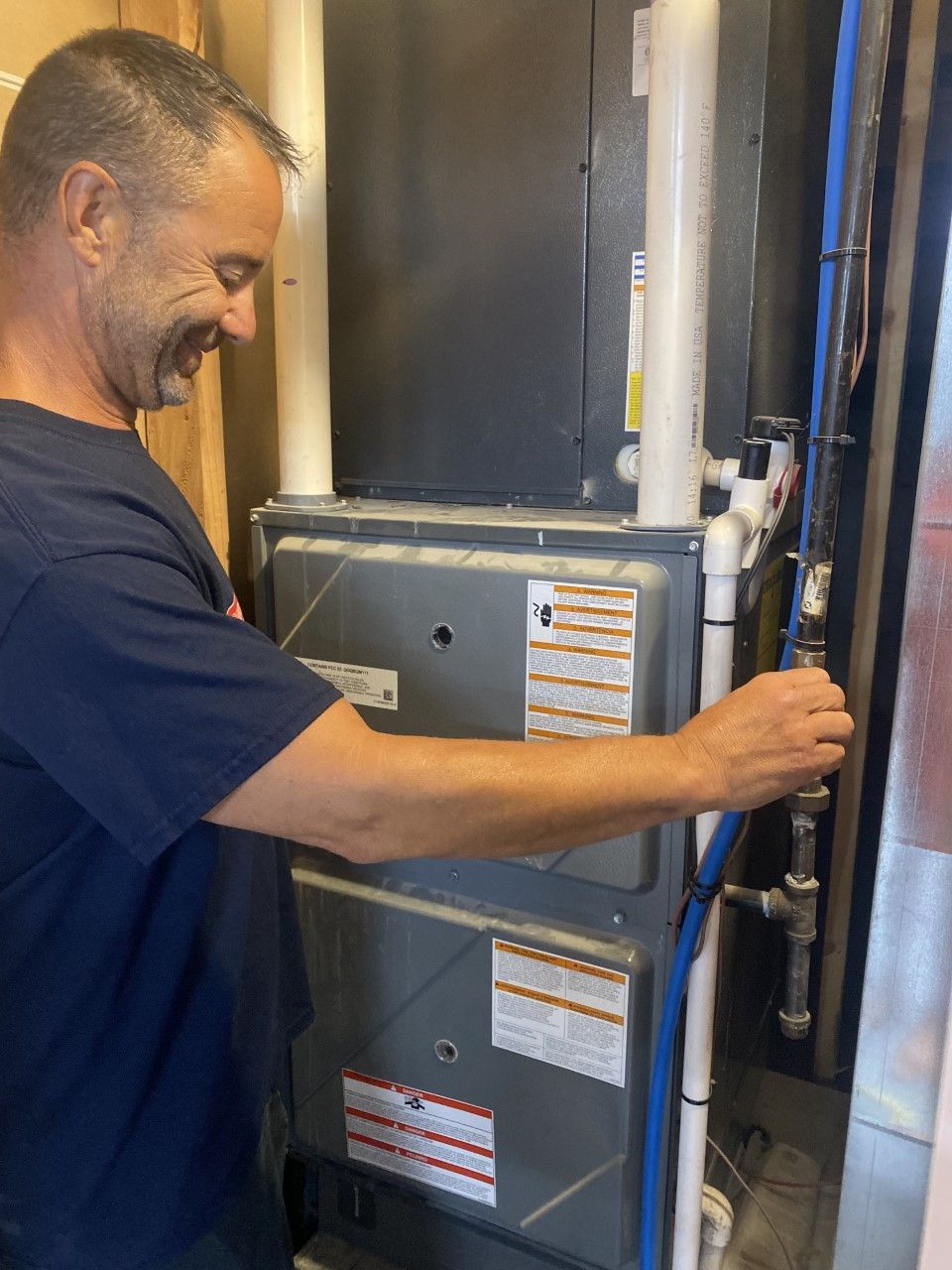 A man is working on an air conditioner in a room.