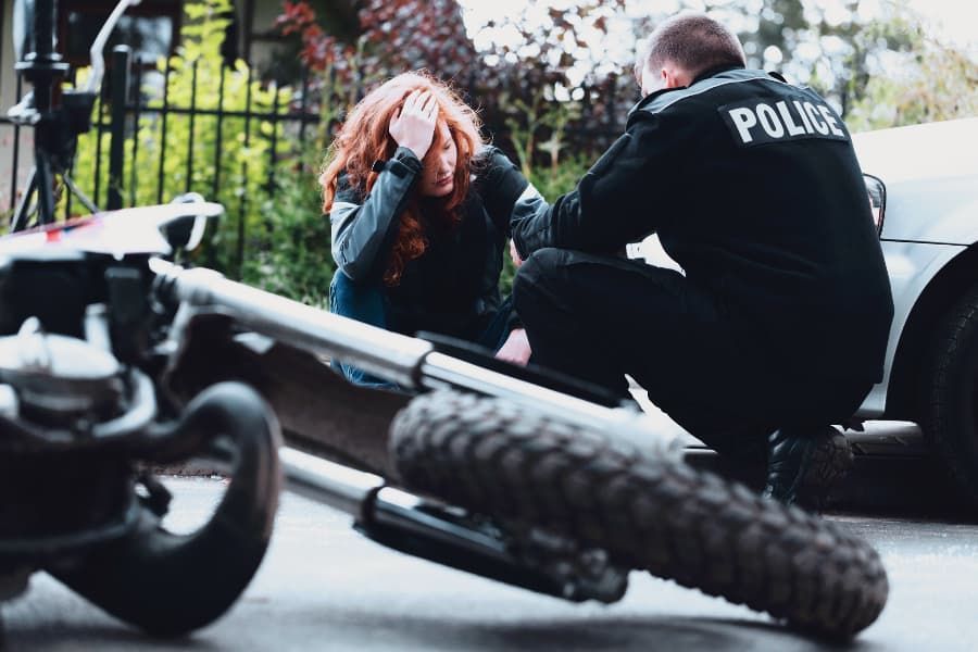 Police officer interviewing an upset rider after a motorcycle crash.