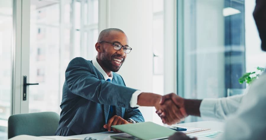 Smiling attorney shaking hands with new client. 
