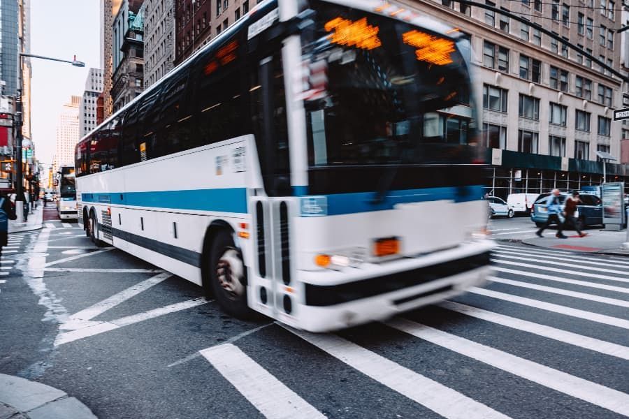 Blurred image of New York City bus approaching crosswalk 