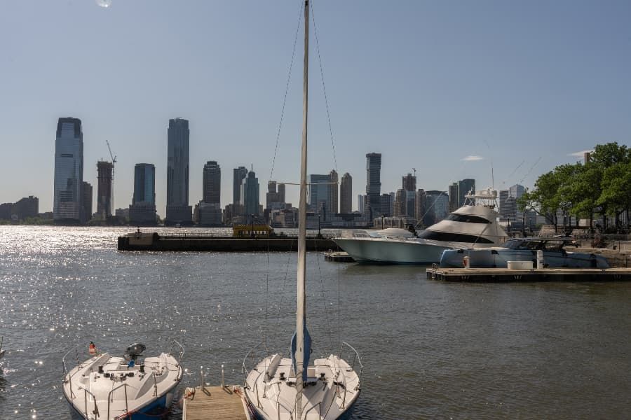 Boats in harbor with New York skyline in background.
