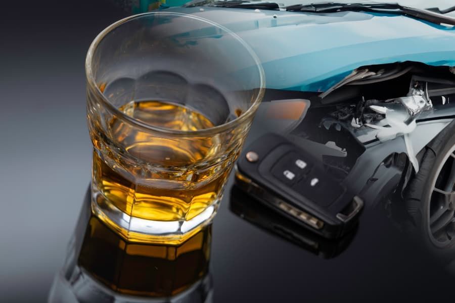 Blurred images of glass of whiskey, key fob, and crashed car.