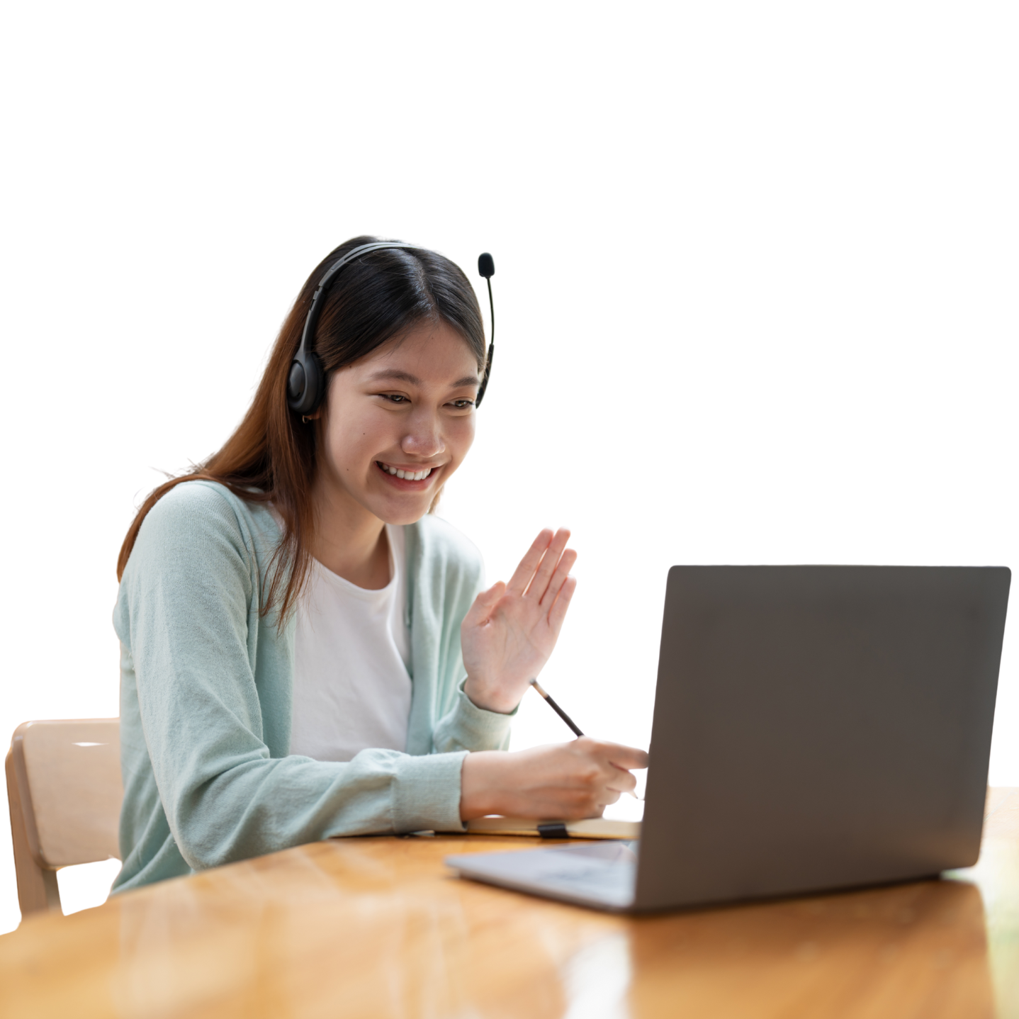 A woman wearing headphones is sitting at a table using a laptop computer.