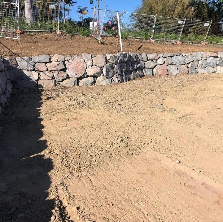 A Stone Wall Is Being Built on Top of A Dirt Field — Webster Rock Walls In Caboolture, QLD