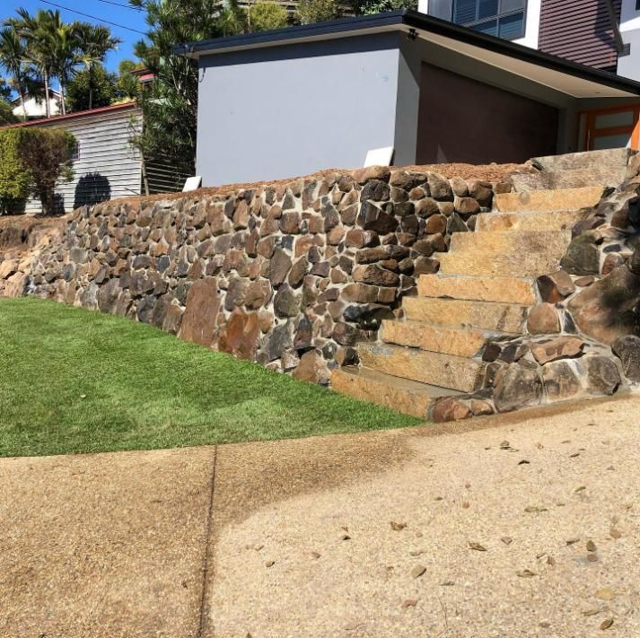 A Stone Wall with Stairs Leading up To a House — Webster Rock Walls In Noosa, QLD