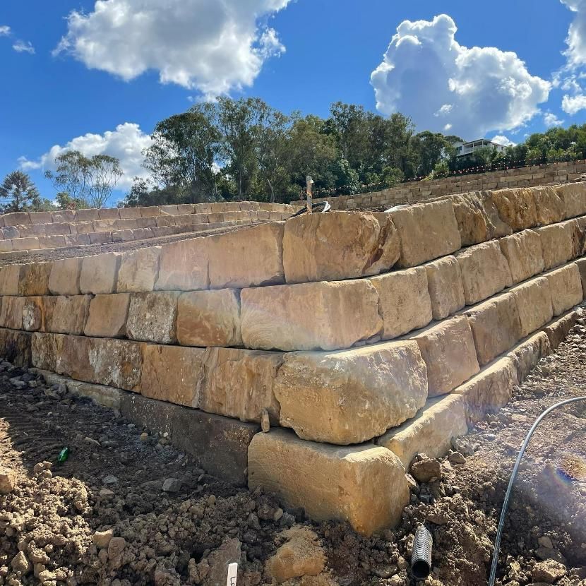 A Large Pile of Rocks Is Sitting on Top of A Dirt Field — Webster Rock Walls In Caboolture, QLD