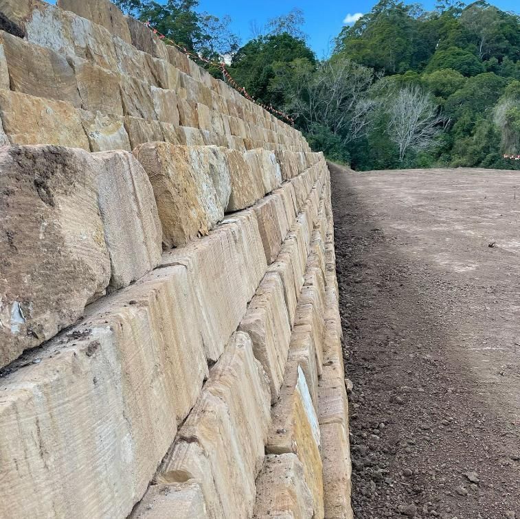 A Large Stone Wall Is Sitting on Top of A Dirt Field — Webster Rock Walls In Maroochydore, QLD