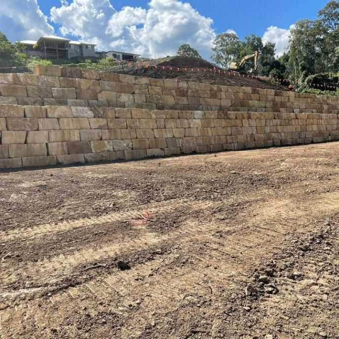 A Large Stone Wall Is Being Built on Top of A Dirt Field — Webster Rock Walls In Maroochydore, QLD