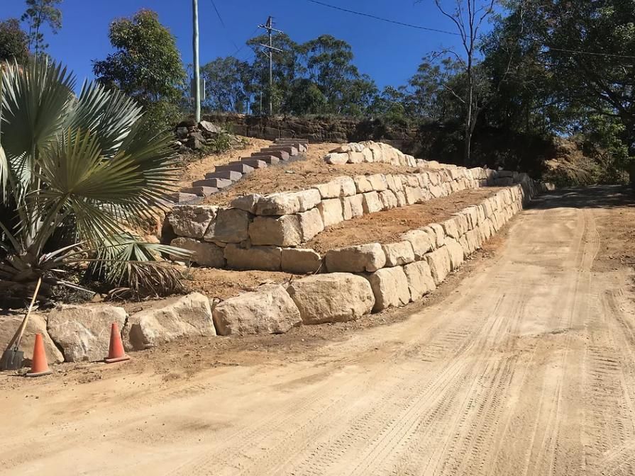 A Dirt Road with A Stone Wall on The Side of It — Webster Rock Walls In Ilkley, QLD