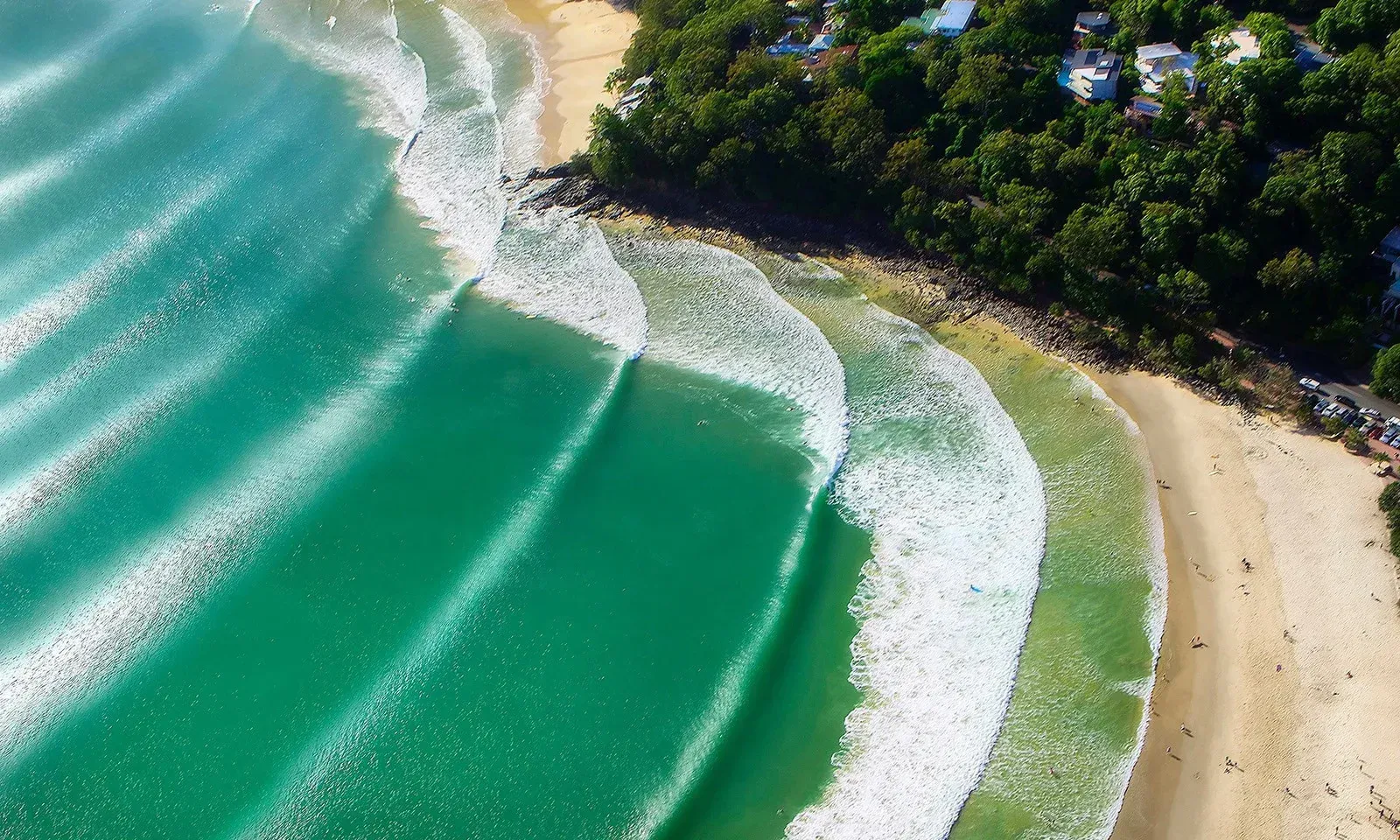 An aerial view of a beach with waves crashing on the shore. — Webster Rock Walls In Noosa, QLD