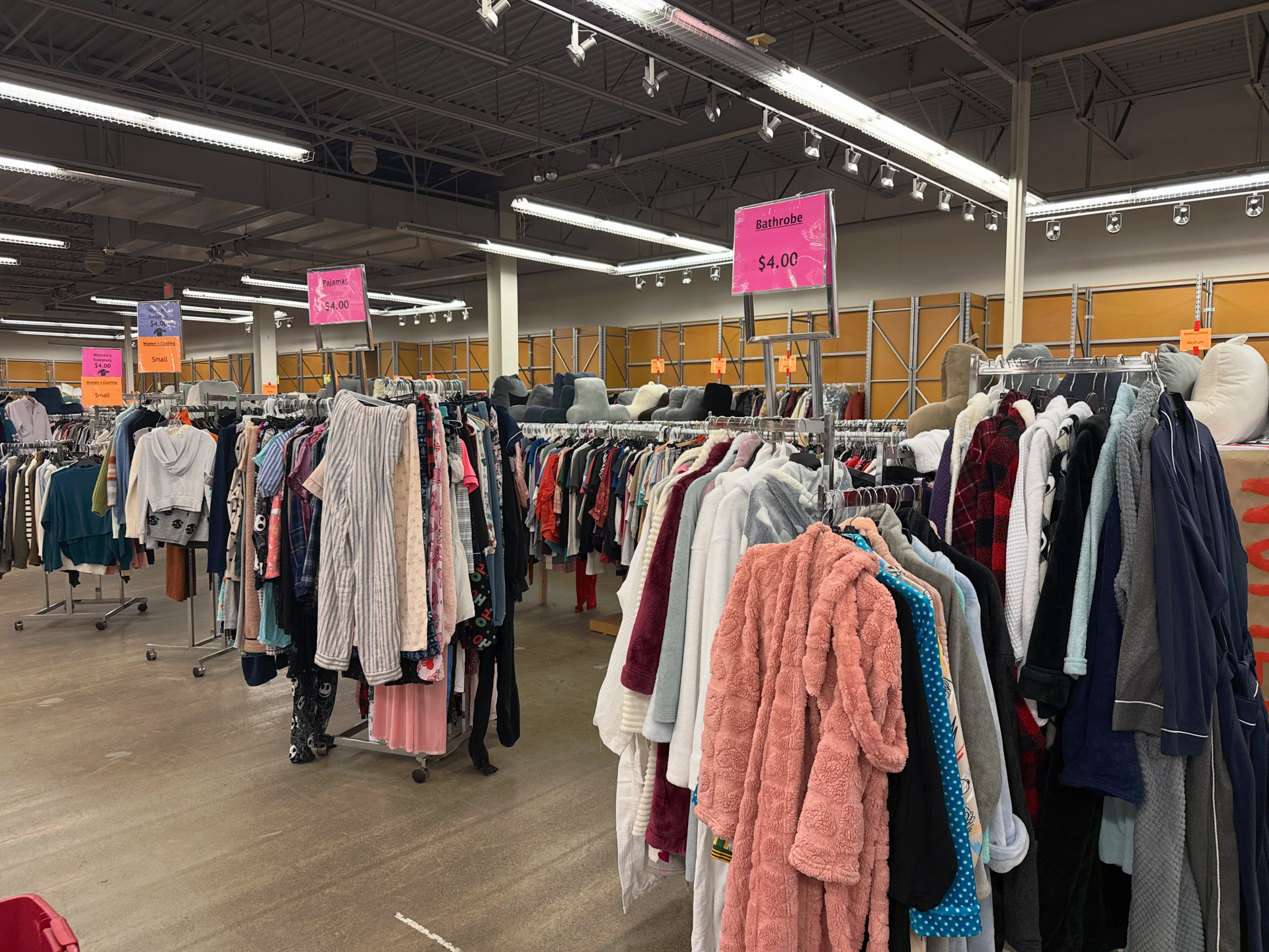 A store filled with lots of clothes hanging on racks.