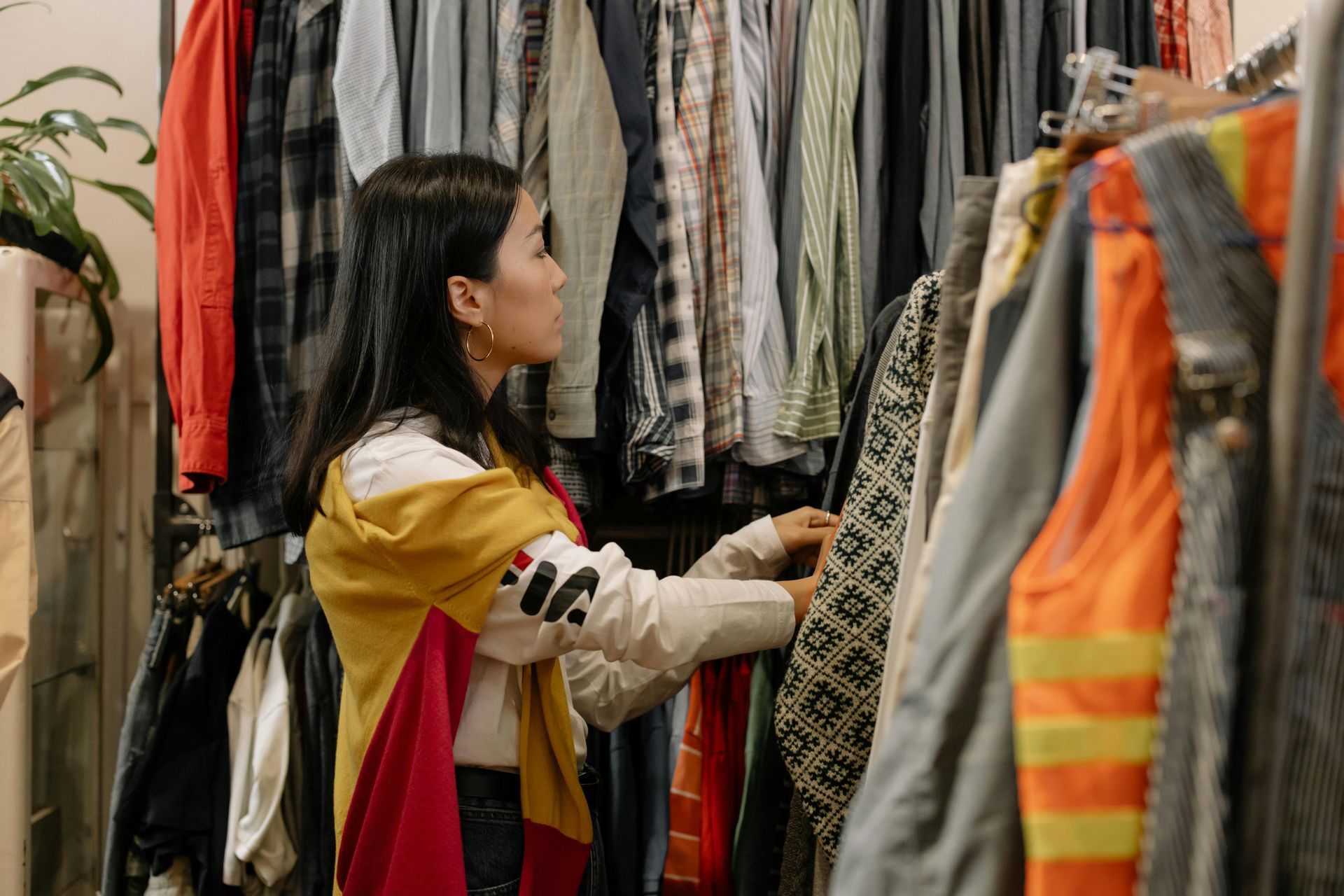 A woman is looking at clothes in a closet.