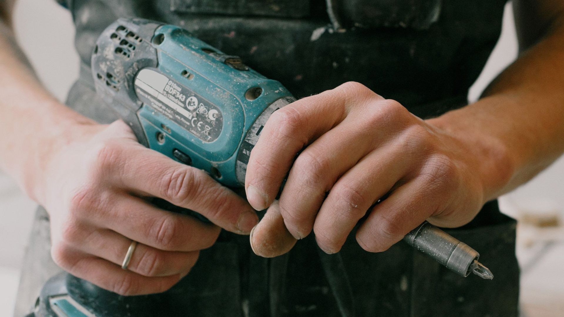 a man is holding a drill in his hands .