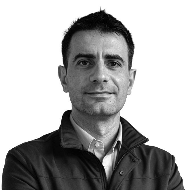 Man wearing a jacket, looking at the camera, against a white background.