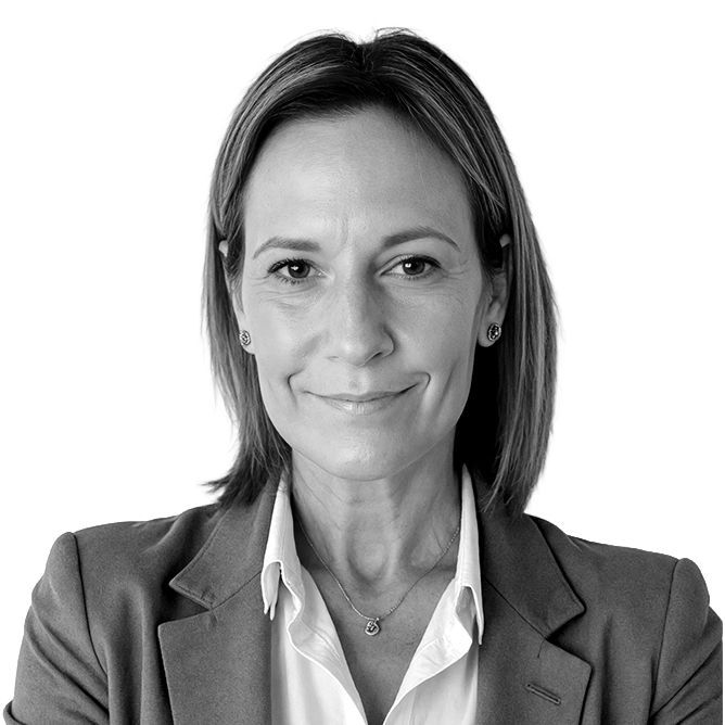 Woman in blazer and collared shirt smiling, headshot.
