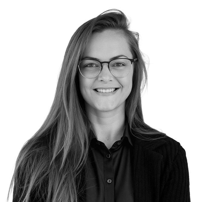 Woman with long hair, glasses, and a black shirt smiles at the camera.