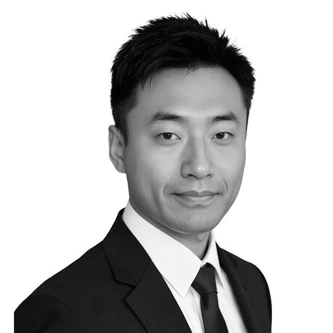 Man in suit and tie looking at the camera, headshot.