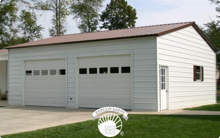 A large white garage with a brown roof