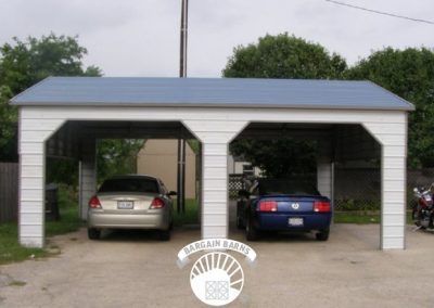 Two cars are parked under a white carport with a blue roof