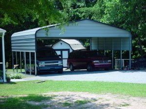 Two cars are parked under a metal carport.