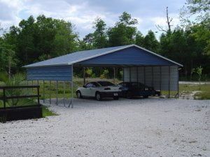 Two cars are parked under a blue carport.