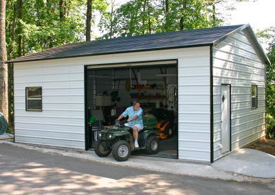 A man is riding an atv into a garage.