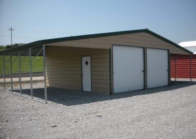 A garage with a green roof and white doors