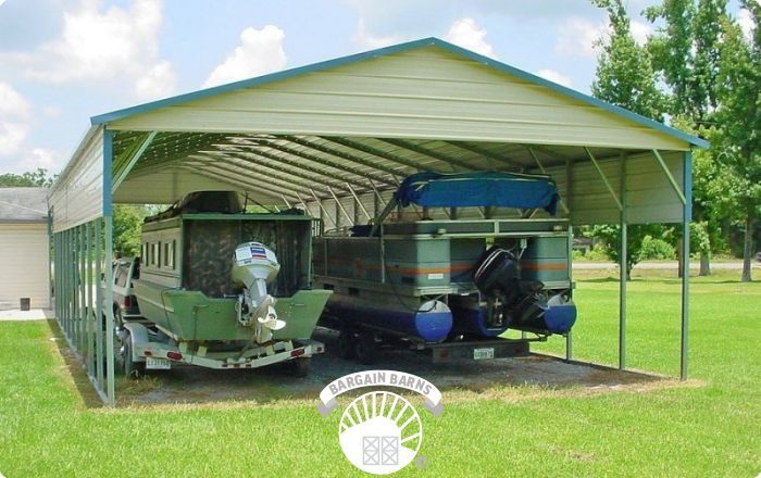 A boat is parked under a metal carport.