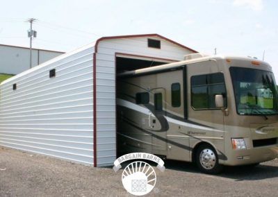 A rv is parked in a garage with the door open
