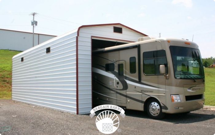 A rv is parked in a garage with the door open