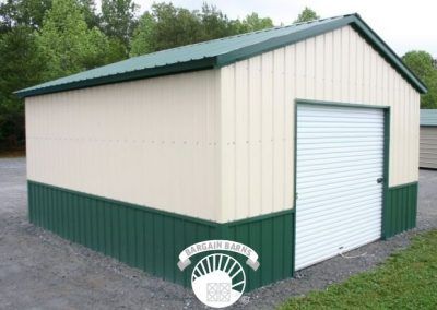 A white and green metal garage with a roll up door.