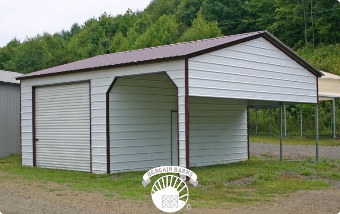 A white garage with a brown roof is sitting in the grass.