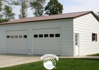 A white garage with two garage doors and a brown roof.