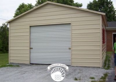 A man is standing in front of a garage with a white door.