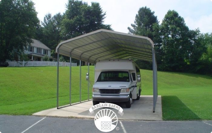 A white van is parked under a canopy in a parking lot