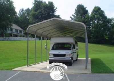A white van is parked under a metal carport