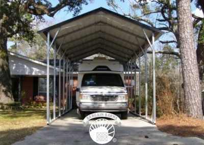 A white van is parked under a carport in front of a house