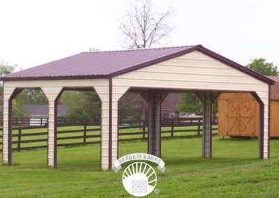 A carport with a purple roof is in the middle of a grassy field.
