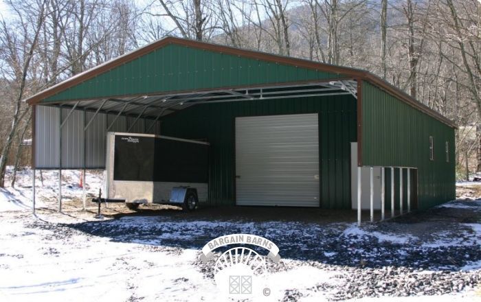 A green garage with a white trailer inside of it