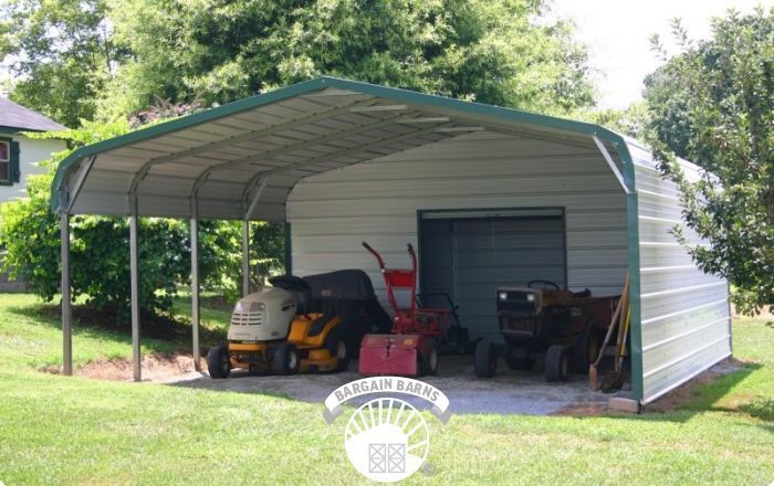 A lawn mower is parked under a carport.