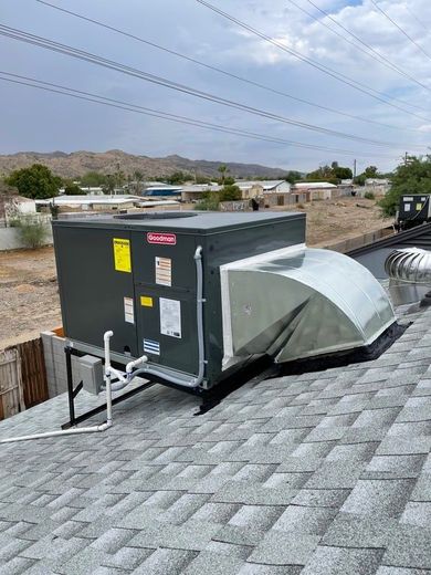 A large air conditioner is sitting on top of a roof.