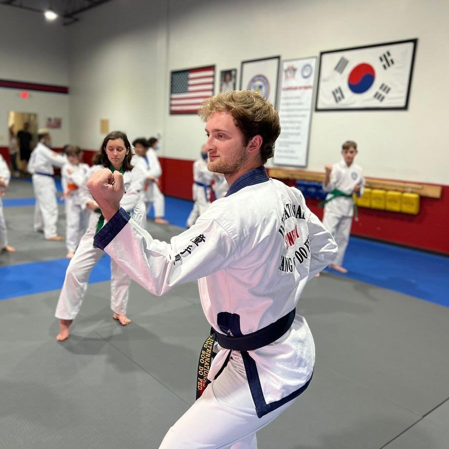 A group of people are practicing martial arts in a gym.