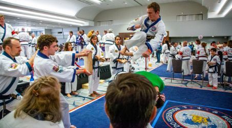 A man is jumping in the air while a group of people watch.