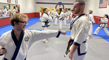 A group of people are practicing martial arts in a gym.