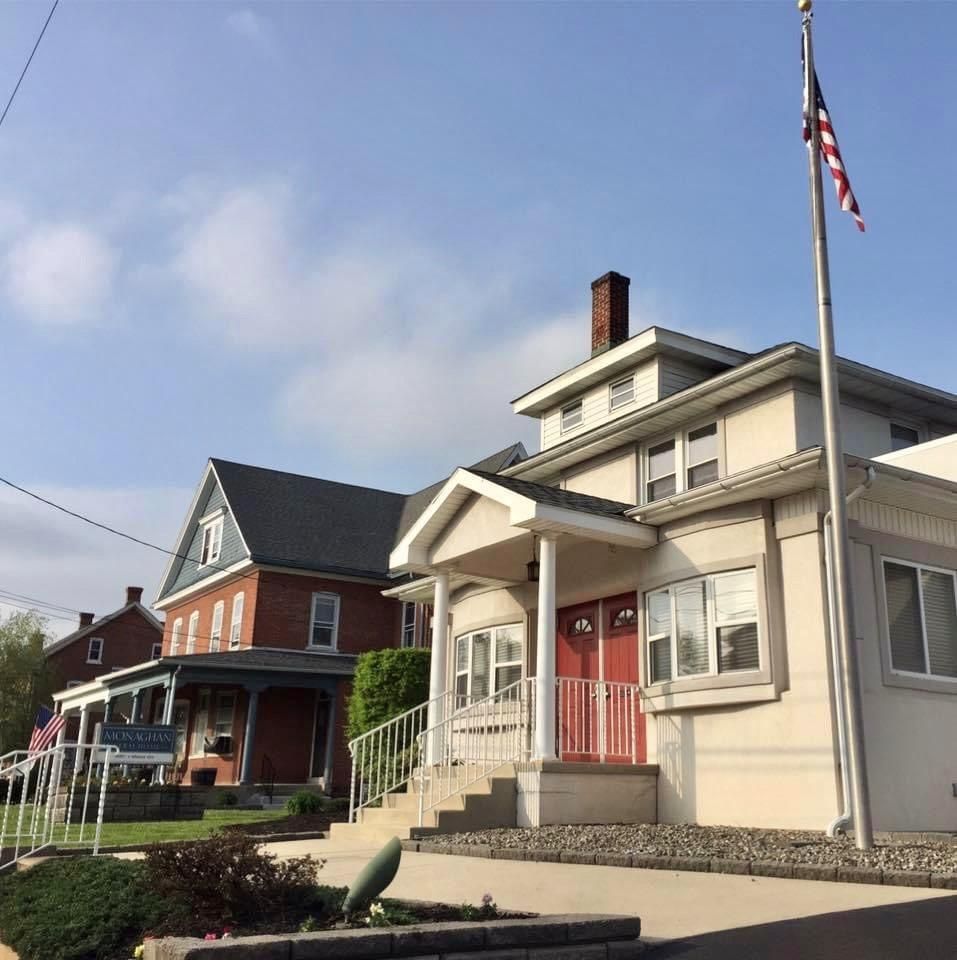 Buildings with an American flag, red doors, and a blue sky.
