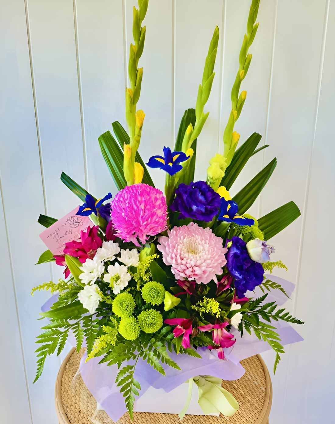 A Bouquet of Flowers is Sitting on a Table in Front of a White Wall — Bundaberg House of Flowers In Burnett Heads, QLD