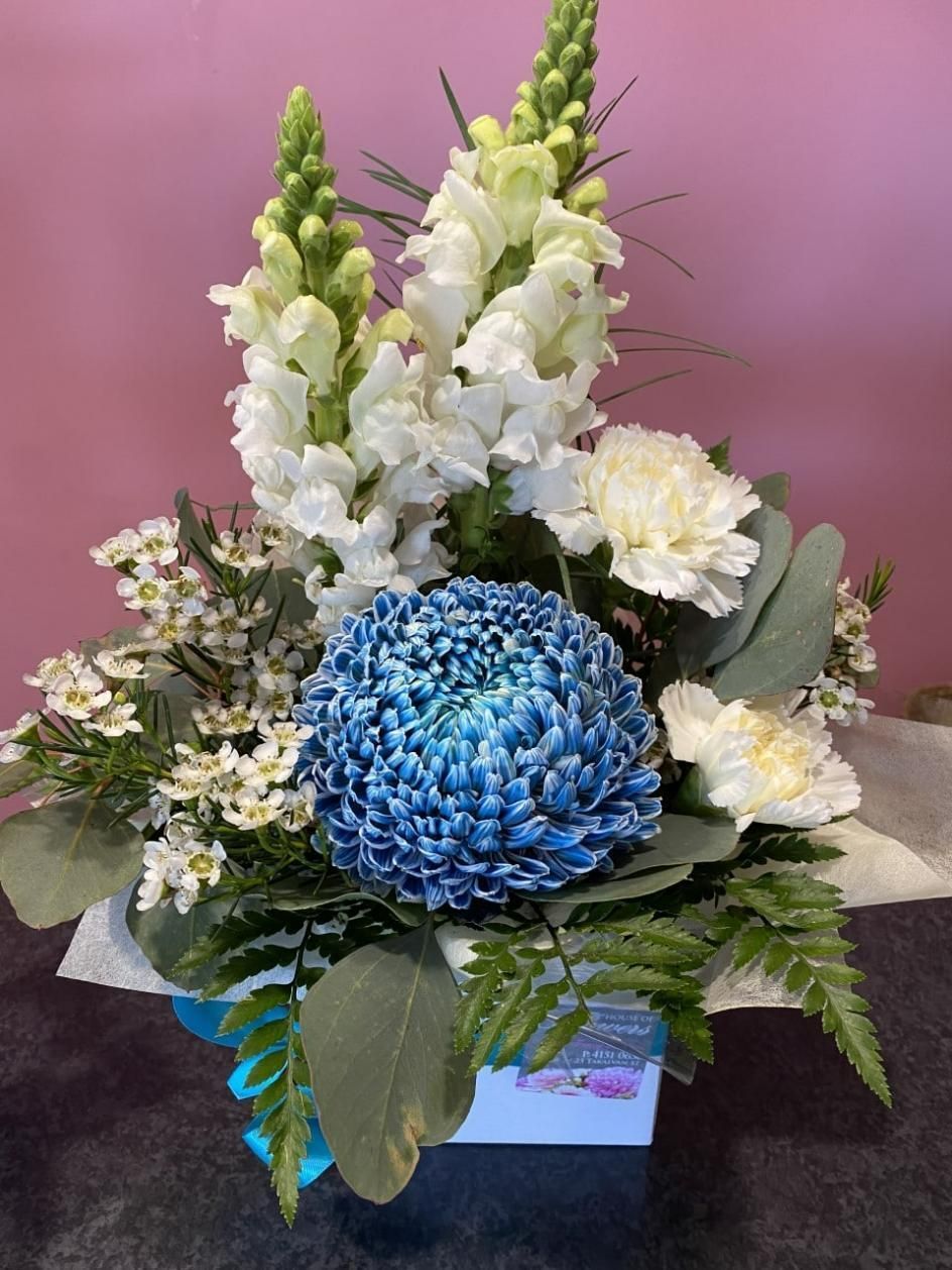 A Vase Filled With White and Blue Flowers on a Table — Bundaberg House of Flowers in Bundaberg West, QLD
